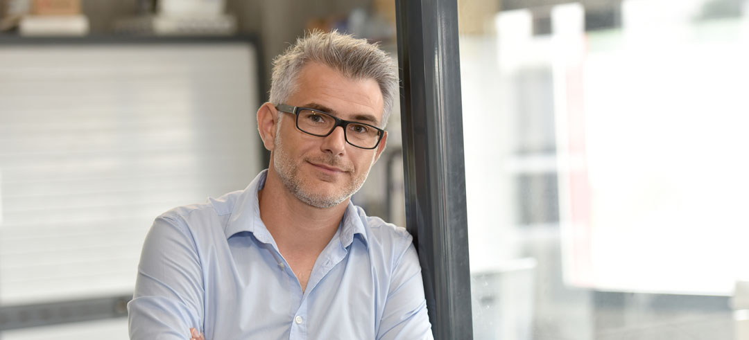 Hombre apoyado en una pared de cristal