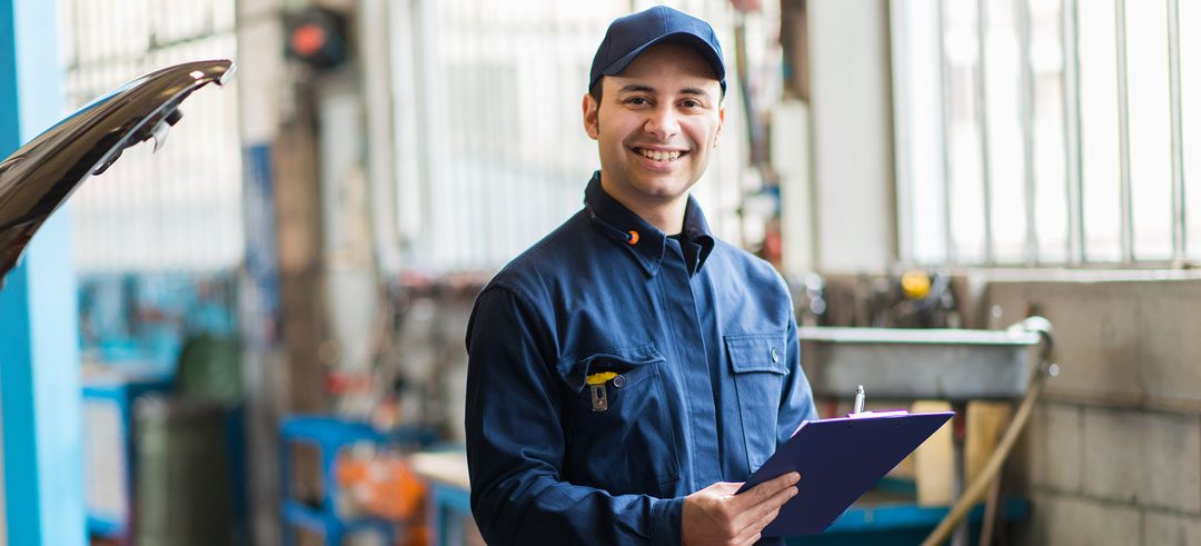 Mecánico de coches sonriendo en el taller
