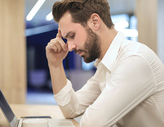Hombre pensativo trabajando con un ordenador