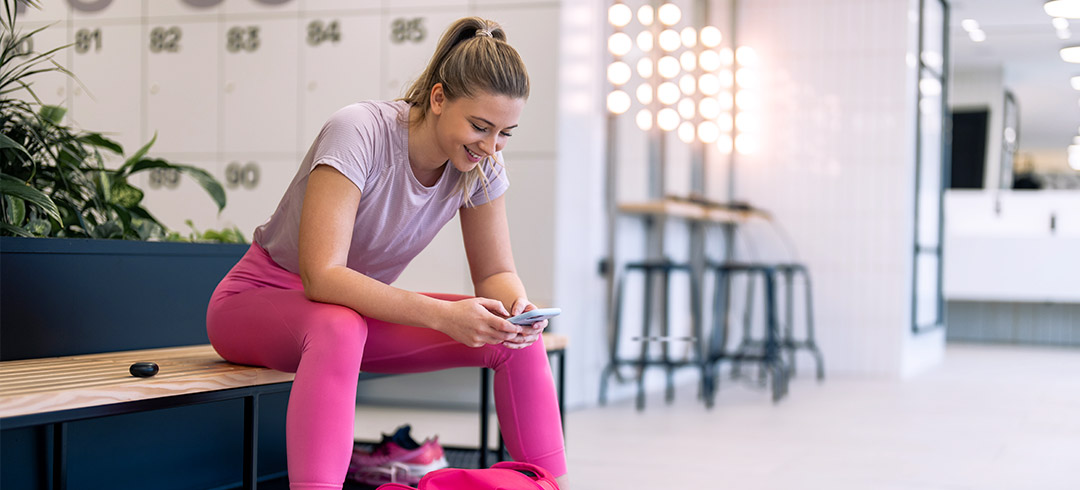 Chica usando su smartphone en un vestuario