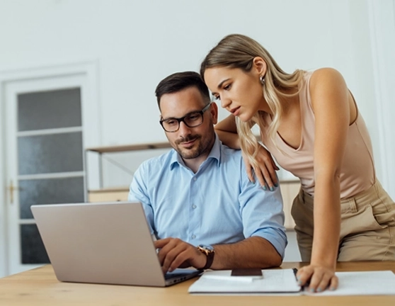 Pareja revisando algo en un ordenador portátil desde casa