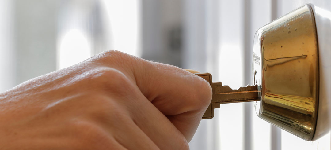 Persona abriendo la cerradura de una casa con la llave