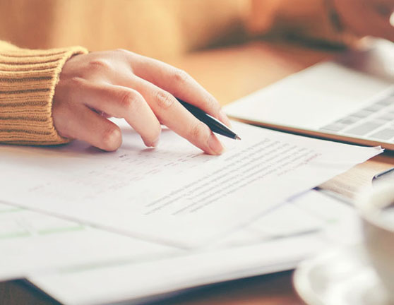 Persona con un ordenador y documentos sobre la mesa